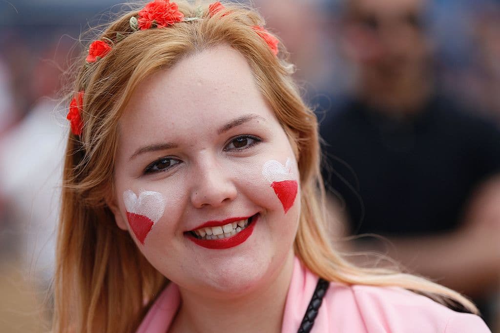 A Poland's supporter poses for a photograph as she watches the Euro 2016 football match Switzerland vs Poland on a giant screen at the Fan zone near the Eiffel tower on June 25, 2016 in Paris. / AFP / MATTHIEU ALEXANDRE (Photo credit should read MATTHIEU ALEXANDRE/AFP/Getty Images)