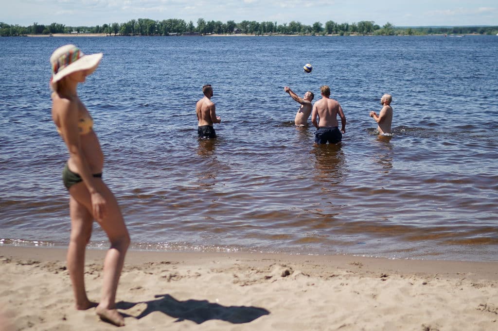 Una residente local ve cómo los visitantes suecos disfrutan de un sol que no es tan común en su país.