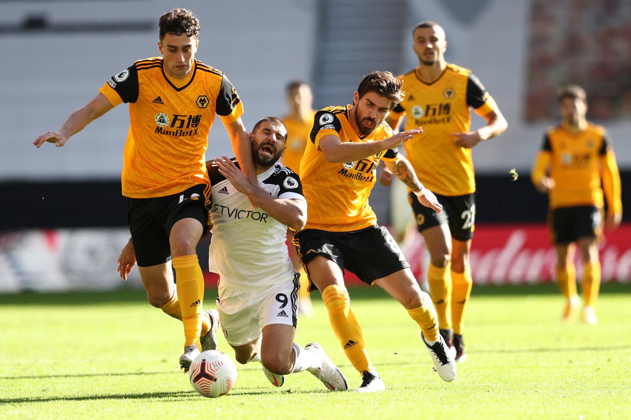 Fulham's Aleksandar Mitrovic, centre, falls during an English Premier League soccer match between Wolverhampton Wanderers and Fulham at the Molineux Stadium in Wolverhampton, England, Sunday Oct. 4, 2020. (Jan Kruger/Pool via AP)