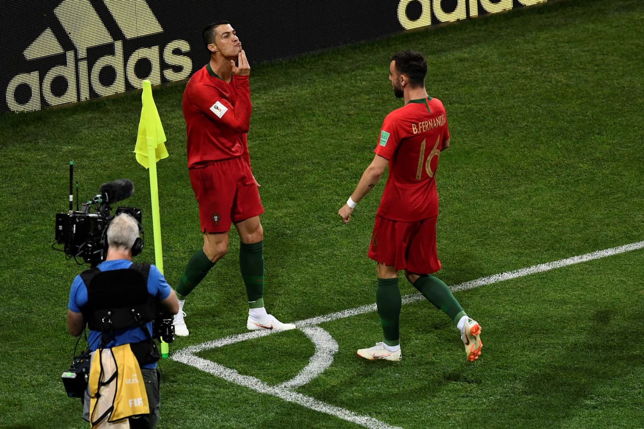 Portugal's forward Cristiano Ronaldo (L) celebrates with Portugal's midfielder Bruno Fernandes after scoring the opening goal during the Russia 2018 World Cup Group B football match between Portugal and Spain at the Fisht Stadium in Sochi on June 15, 2018. (Photo by Jonathan NACKSTRAND / AFP) / RESTRICTED TO EDITORIAL USE - NO MOBILE PUSH ALERTS/DOWNLOADS (Photo credit should read JONATHAN NACKSTRAND/AFP/Getty Images)