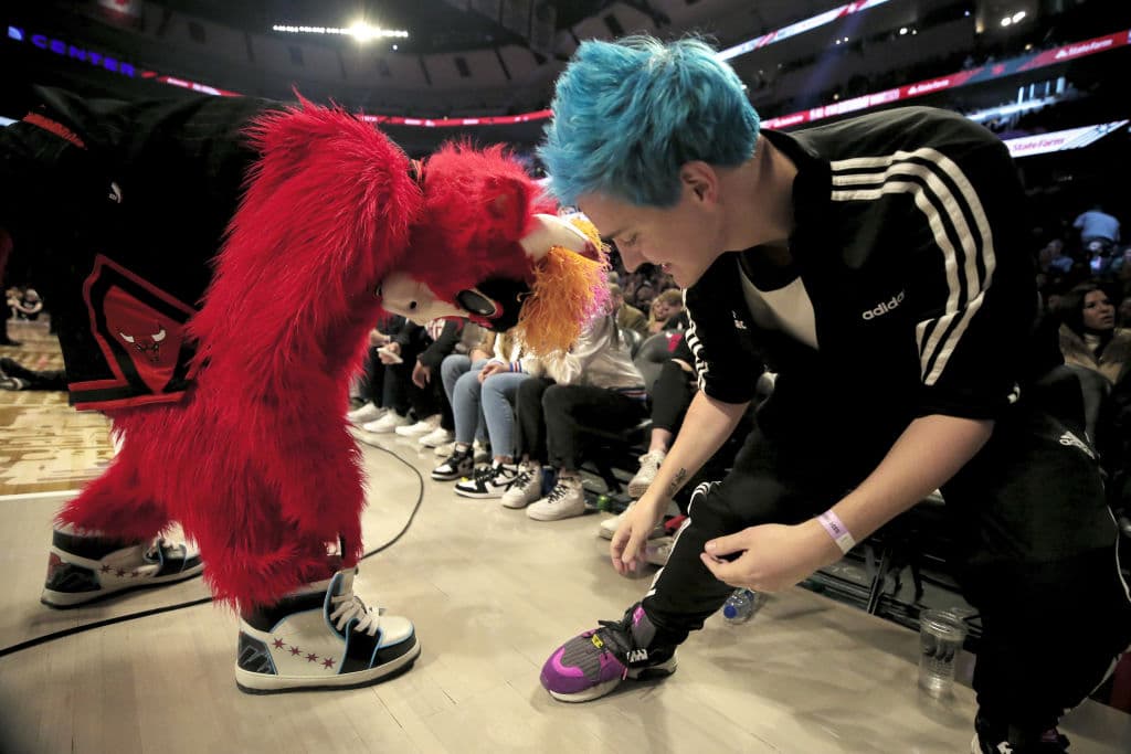 Benny el Toro y Tyler "Ninja" Blevins comparan sus tenis en el concurso de Clavadas durante el juego All-Star de la NBA.