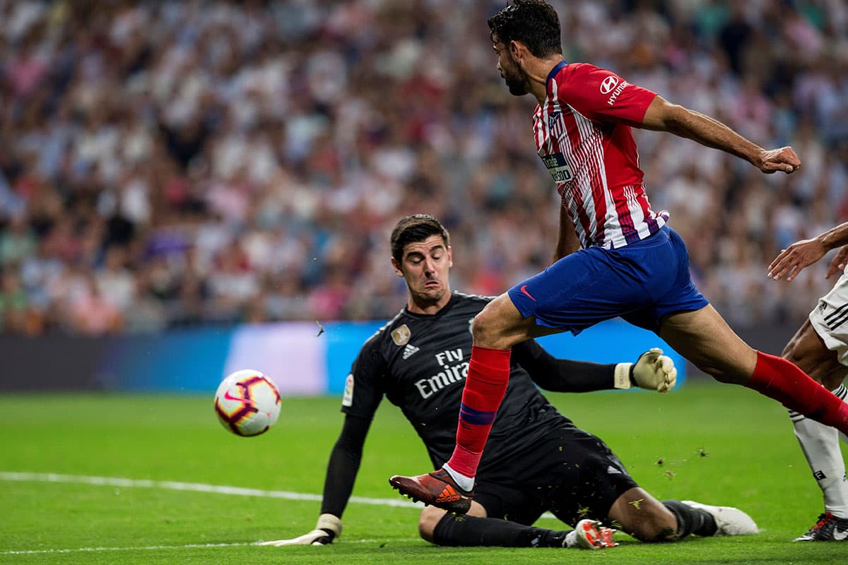 Otra de las intervenciones del arquero del Real Madrid, Thibaut Courtois, en mano a mano con Diego Costa (derecha).
