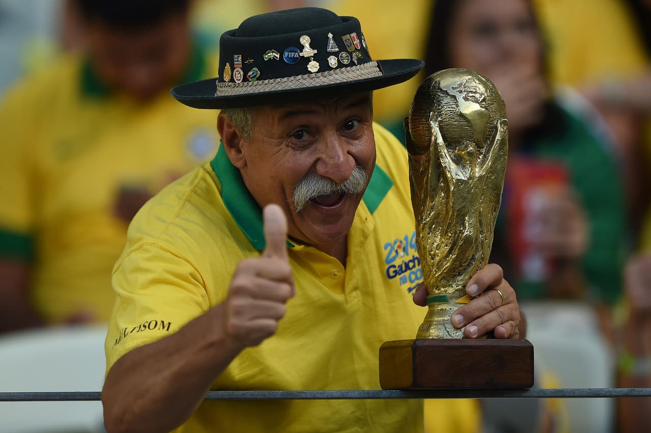 A Brazil's supporter poses with a World Cup trophy replica prior to the quarter-final football match between Brazil and Colombia at the Castelao Stadium in Fortaleza during the 2014 FIFA World Cup on July 4, 2014. AFP PHOTO / EITAN ABRAMOVICH (Photo credit should read EITAN ABRAMOVICH/AFP/Getty Images)