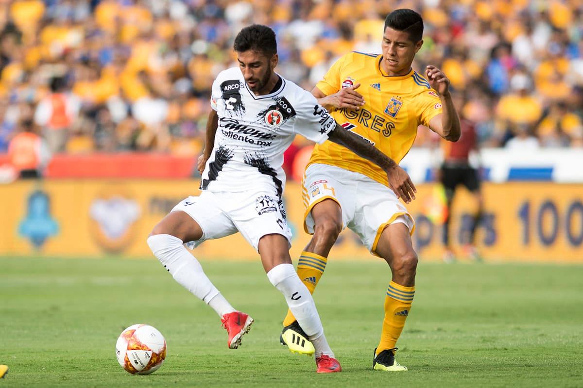 El delantero argentino de Xolos Juan Martín Lucero (izquierda), marcado en esta jugada por Hugo Ayala, no tuvo suerte para anotar.