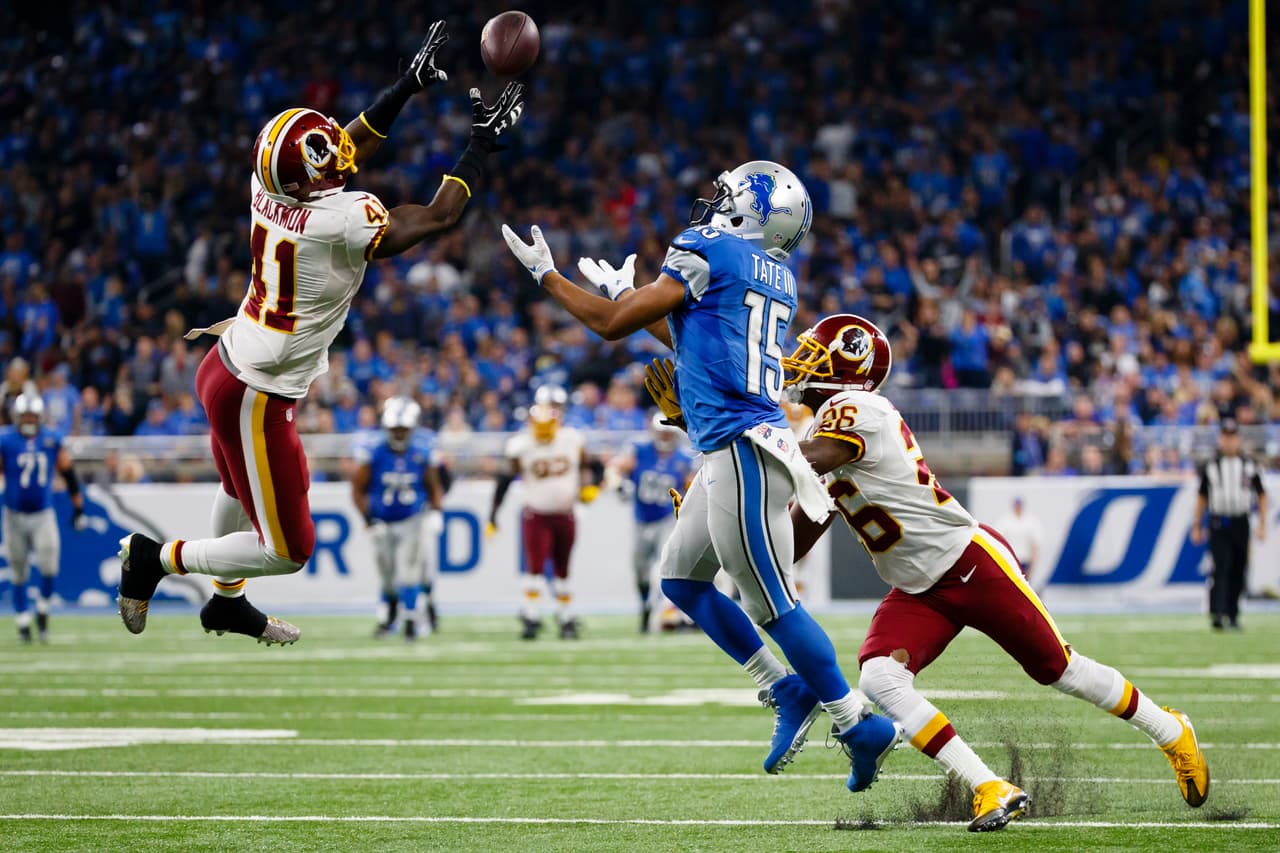 El profundo de los Redskins, Will Blackmon, tratándose de llevar este pase dirigido a Golden Tate.