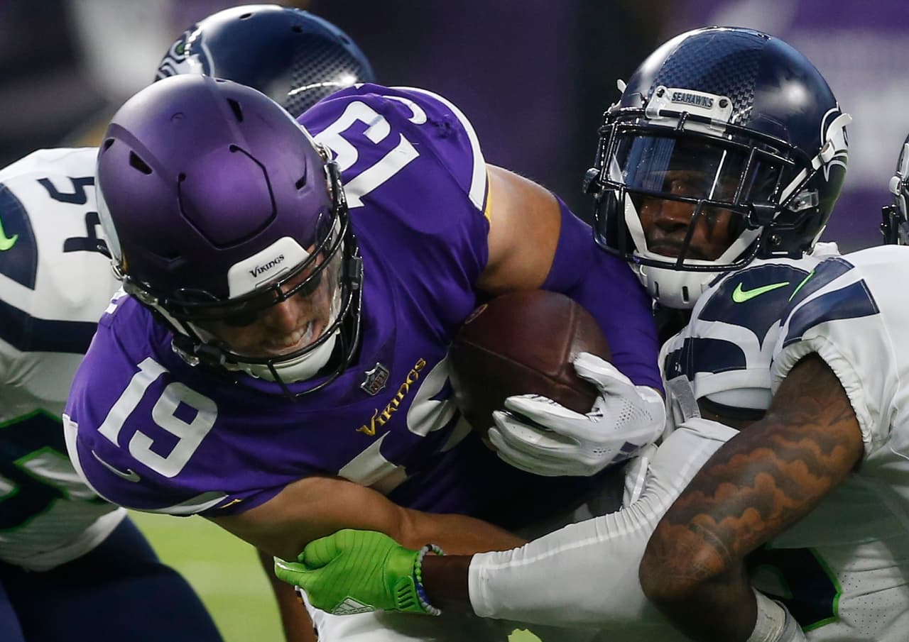 Los Seattle Seahawks acumularon su tercera derrota de pretemporada al caer en su visita a los Minnesota Vikings por 21-20. Adam Thielen (izquierda) de los Vikings, es tacleado por Justin Coleman.