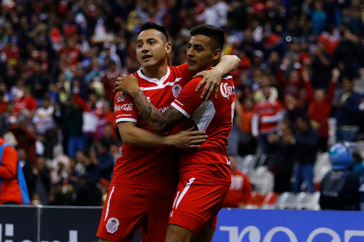 Apenas a los dos minutos Alexis Vega (derecha) anotó el primer gol del partido para Toluca, celebrando con su compañero Antonio Ríos (izquierda).