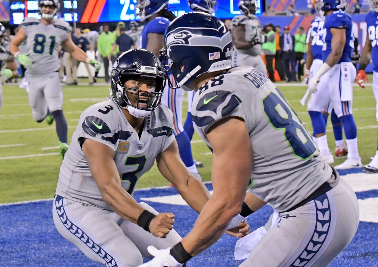 Seattle Seahawks quarterback Russell Wilson, left, celebrates with Jimmy Graham after Graham caught a touchdown pass during the second half of an NFL football game against the New York Giants, Sunday, Oct. 22, 2017, in East Rutherford, N.J. (AP Photo/Bill Kostroun)