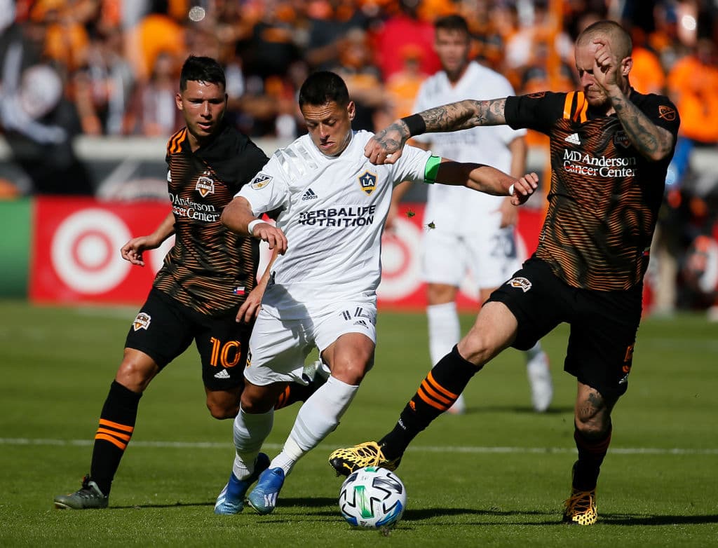 Chicharito logra salir de enmedio de los jugadores del Houston Dynamo Tomas Martinez y Kiki Struna.