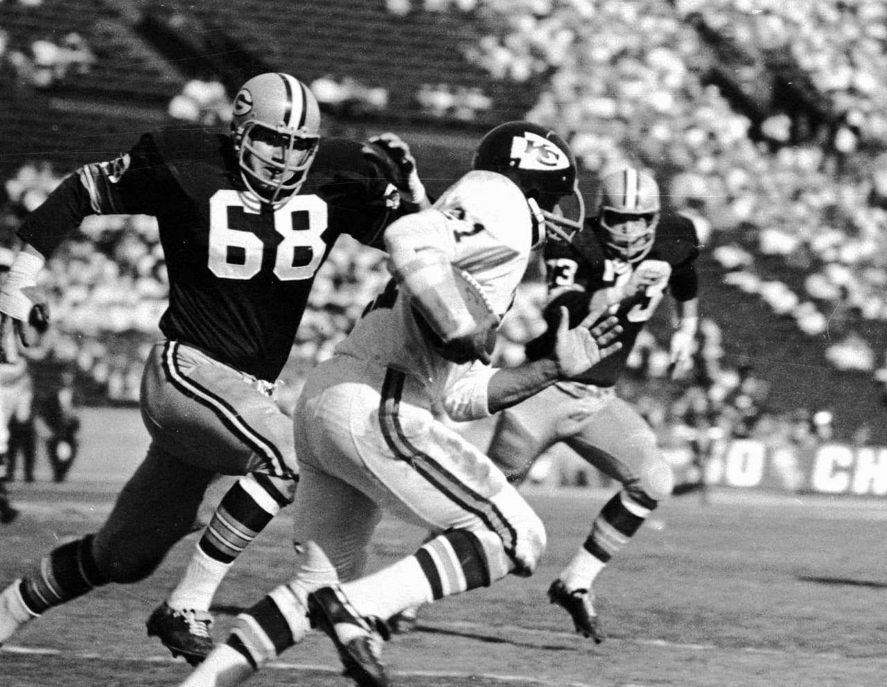 Mike Garrett (21) de los Chiefs intentó evadir a dos defensivos de Green Bay. En dicho Super Bowl logró 45 yardas combinadas entre terrestres (17) y aéreas (28).