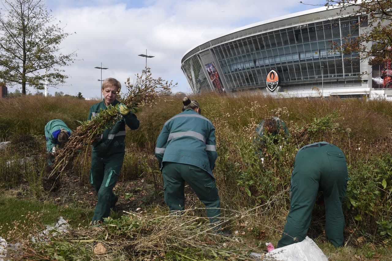 A picture taken on September 16, 2014 in Donetsk shows gardeners working around the Donbass arena stadium, the home stadium of Shakhtar Donetsk football club, eastern Ukraine. AFP PHOTO/PHILIPPE DESMAZES (Photo credit should read PHILIPPE DESMAZES/AFP/Getty Images)