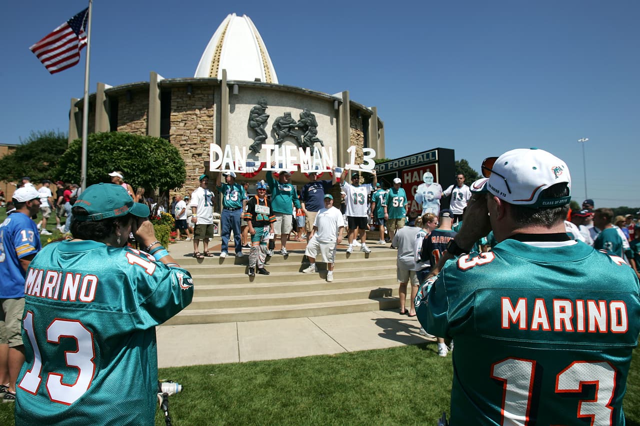 CANTON, OH - AUGUST 7: Fans with a sign saying "Dan The Man #13" in reference to Hall of Fame enshirnee Dan Marino of the Miami Dolphins, pose for other fans who take pictures in front of the Pro Football Hall of Fame before the 2005 NFL Hall of Fame enshrinement ceremony on August 7, 2005 in Canton, Ohio. (Photo by Jonathan Daniel/Getty Images)