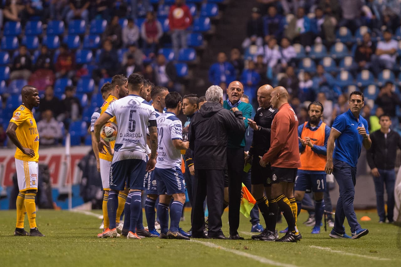 Los dos técnicos cara a cara, Ricardo 'Tuca' Ferreti (centro, de espaldas) y José Luis Sánchez Solá 'Chelís' en el desenlace del duelo entre Puebla y Tigres por el
<a href="https://www.univision.com/deportes/futbol/liga-mx/*">Clausura 2019</a>.