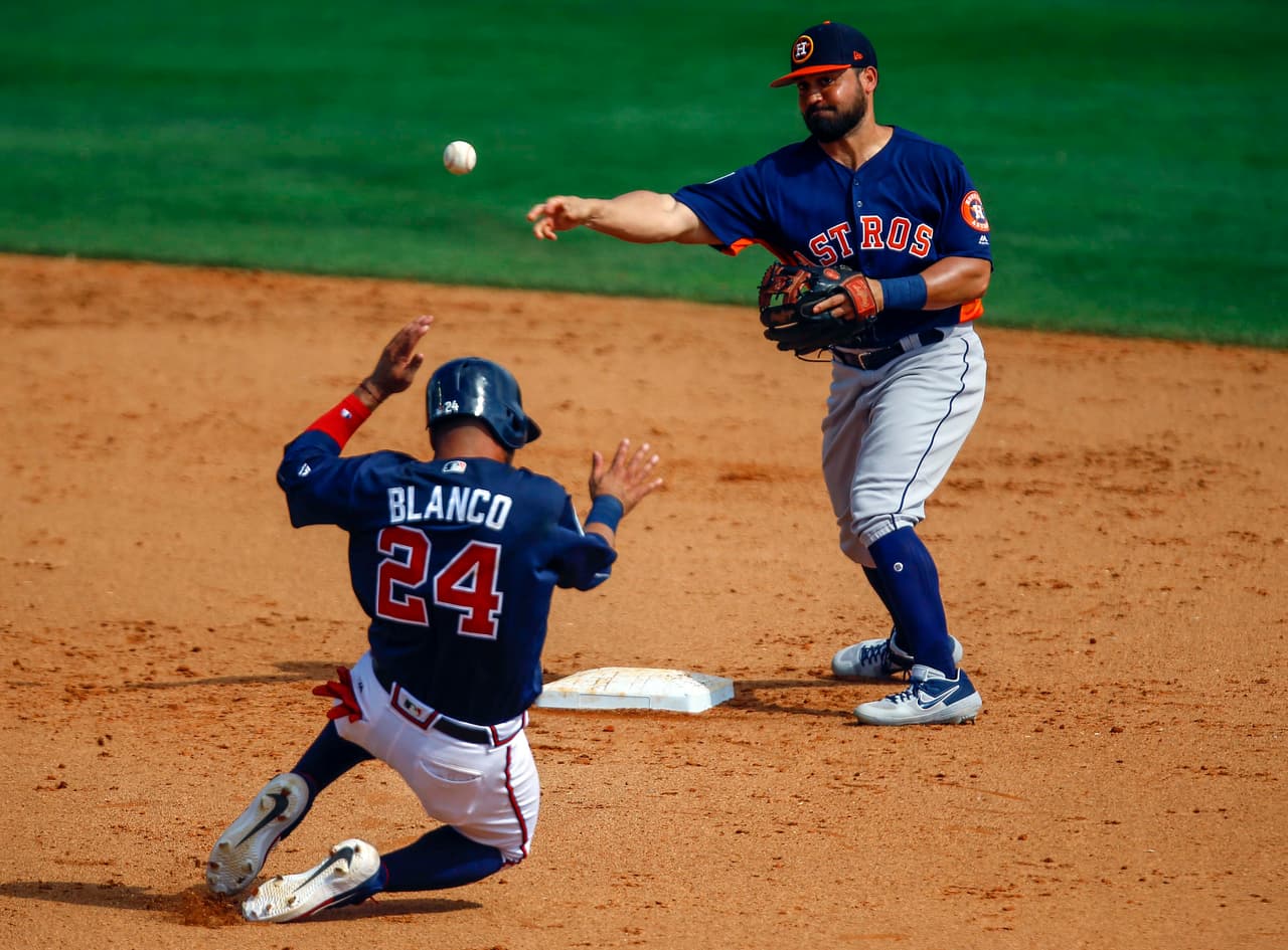 El shortstop de los Astros Jack Mayfield lanza hacia la inicial para completar una doble matanza ante la barrida de Blanco para intentar romper la jugada.