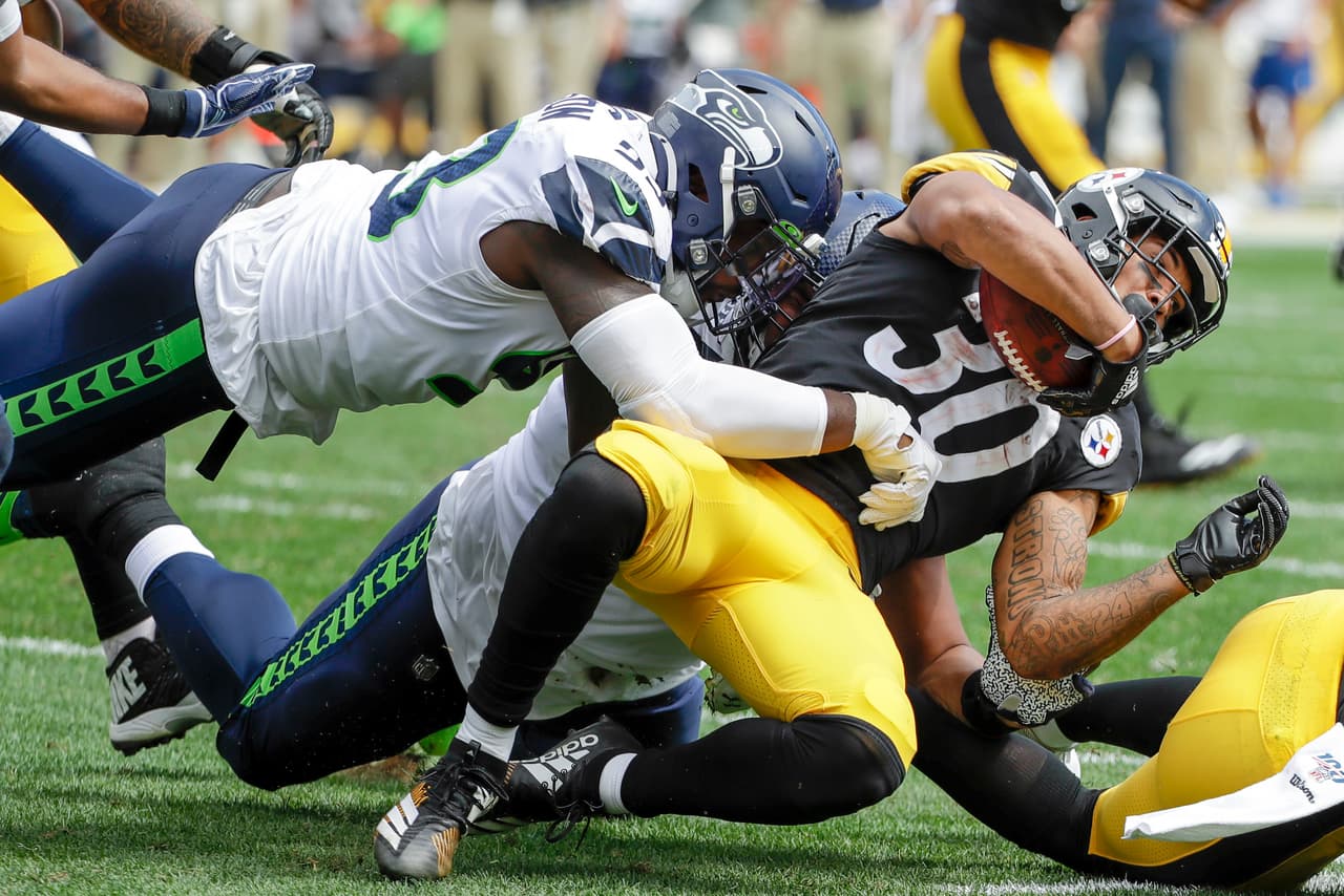 James Conner (30) es golpeado por Joey Hunt (53).