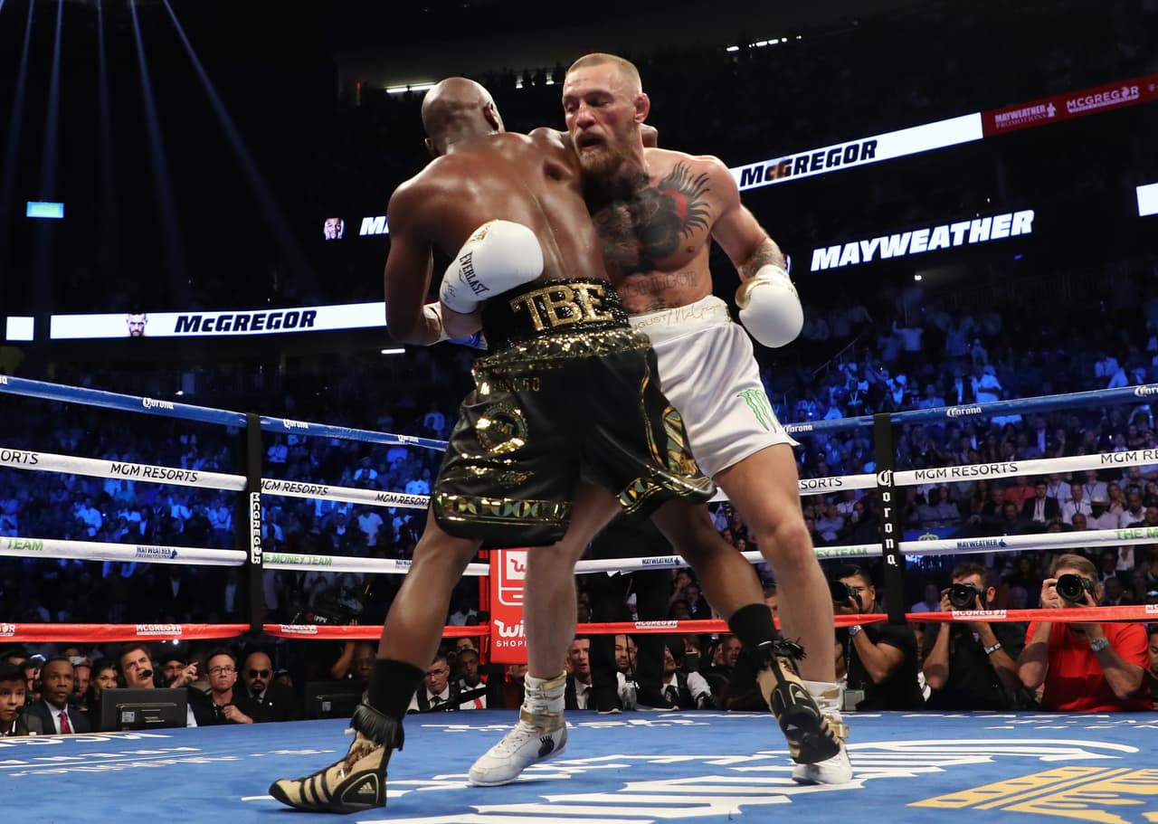 LAS VEGAS, NV - AUGUST 26: (R-L) Conor McGregor throws a punch at Floyd Mayweather Jr. during their super welterweight boxing match on August 26, 2017 at T-Mobile Arena in Las Vegas, Nevada. (Photo by Christian Petersen/Getty Images)