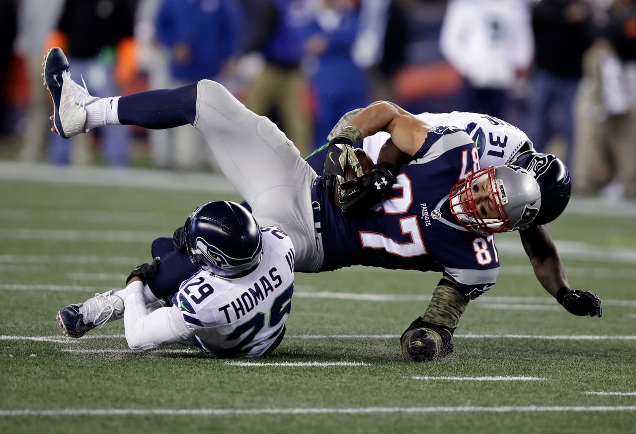 Seattle Seahawks safeties Earl Thomas (29) and Kam Chancellor (31) tackle New England Patriots tight end Rob Gronkowski (87) during the first half of an NFL football game, Sunday, Nov. 13, 2016, in Foxborough, Mass. (AP Photo/Charles Krupa)