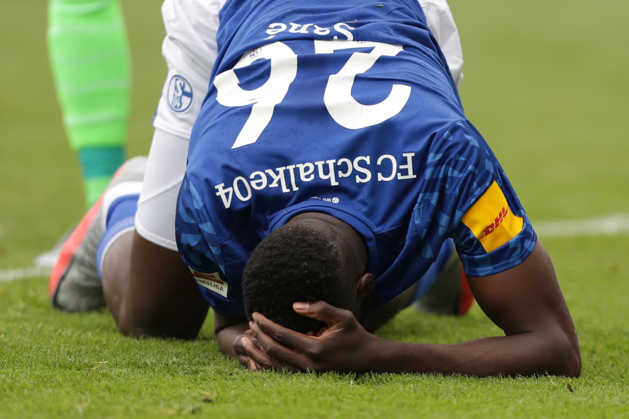 Duro choque tras un corte de balón; Salif Sané se duele de la cabeza en el césped.