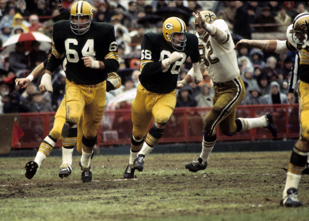 Green Bay Packers guards Jerry Kramer (64) and Gale Gillingham (68) lead the patented Packers sweep during a 29-7 victory over the New Orleans Saints on November 17, 1968, at Milwaukee County Stadium in Milwaukee, Wisconsin. (AP Photo/Vernon Biever)
