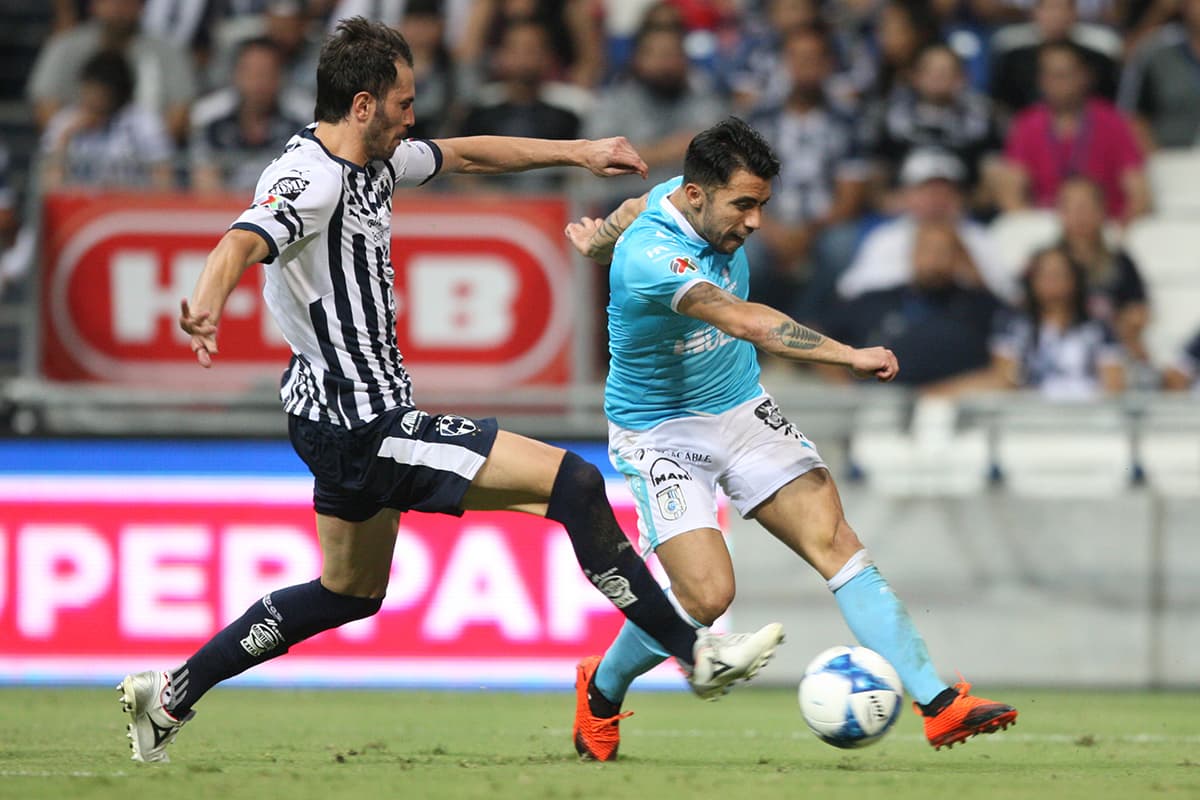 El argentino José María Basanta del Monterrey (izquierda) con un oportuno cierre ante el delantero chileno del Querétaro, Edson Puch (derecha).