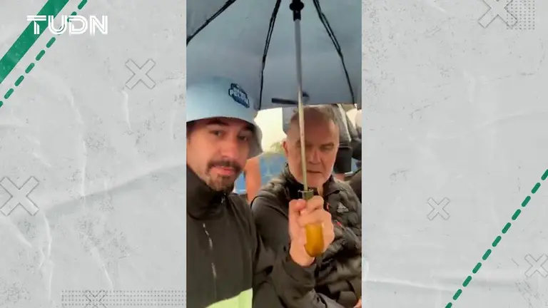 A fan surprises and offers an umbrella to Marcelo Bielsa during the match  Todden Football